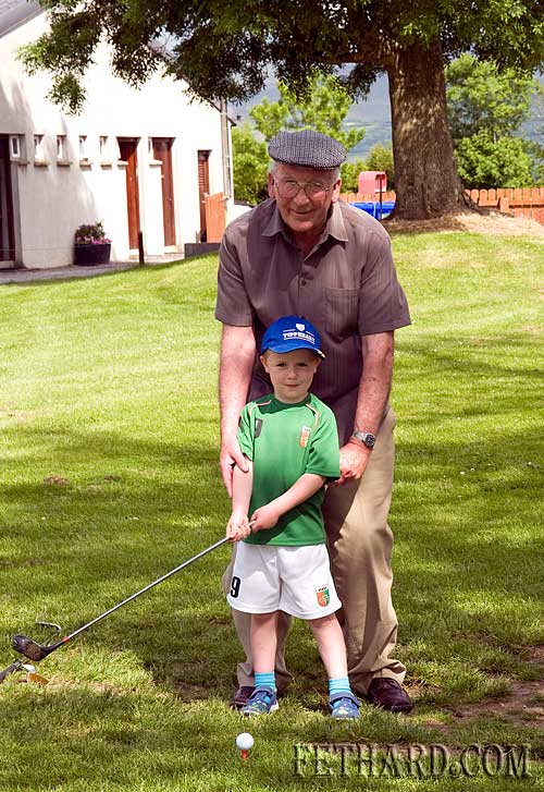 Retired teacher Paddy Broderick giving his grandson Dan a few lessons in his new sport at Slievenamon Golf Club