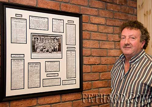 Matty Tynan photographed with framed clips of match previews and reports taken from the Nationalist of 1934.