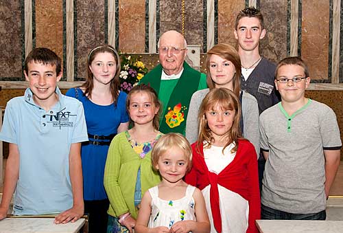 Fr. Joe Walsh OSA photographed with L to R: Kevin Hickey, Kate Guinan, Ava Hickey, Sari Miller, Katie Miller (red), Ellen Walsh, Daniel Guinan and James Walsh.