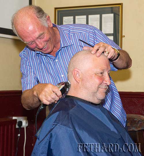 Larry Hopkins having his head and beard shaved by barber, Leo Swift, at Lonergan's Bar in aid of the Special Olympics Fund