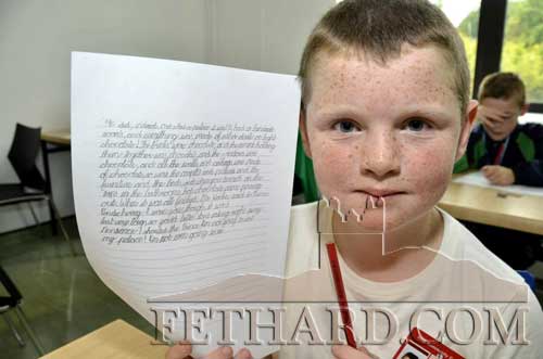 Dara O'Meara proudly displaying his exhibit in the handwriting event at the HSE Community Games National finals.
