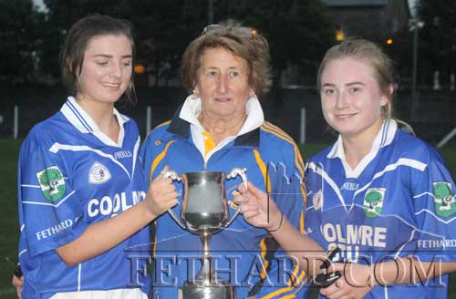 Ladies Football chairperson, Biddy Ryan (centre), presenting the County Junior B Cup to joint captains Ciara Hayes (left) and Megan Coen. 
