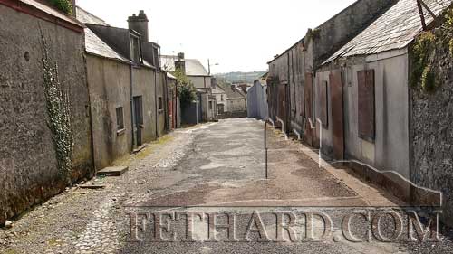 Chapel Lane, Fethard, as it looked in April 2013, with cobble stoned drains on both sides, and on the building on the right you will see the small plaque situated between the blocked up door and window.