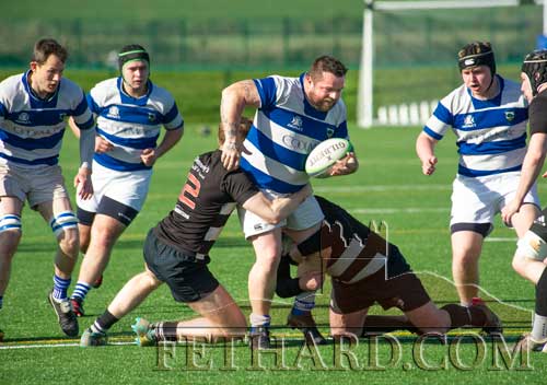 Fethard's Mike Lawrence making his presence felt as Ballicollig players try to take him down.